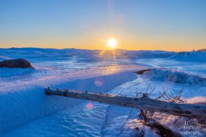 Sunset over the frozen lake in the winter.